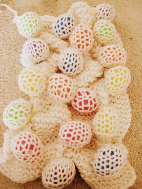 Plastic eggs tied into knitted piece.
